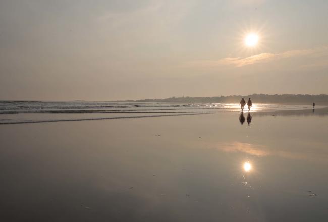 Two people walking on beach